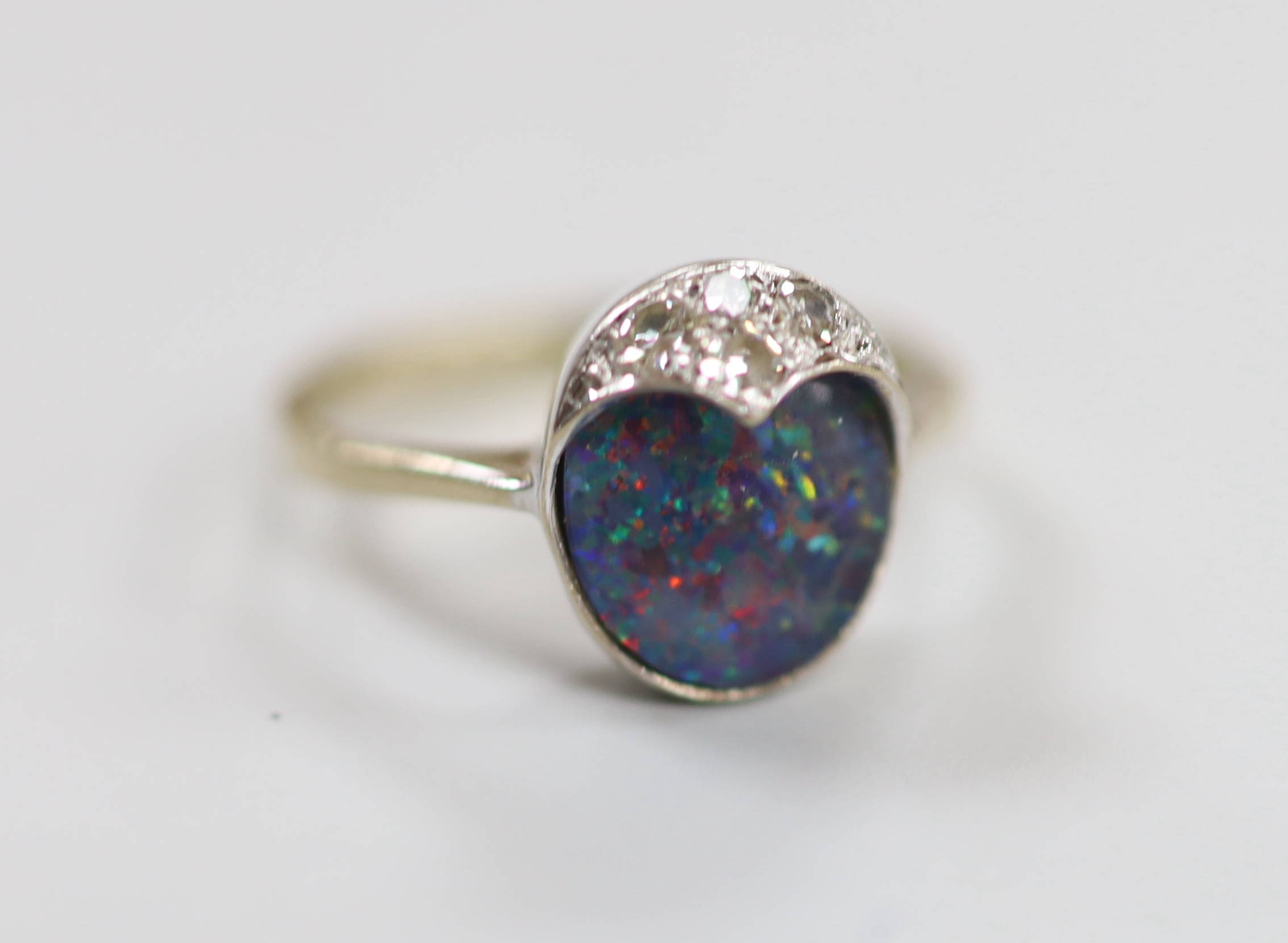 An 18ct white gold, black opal doublet and three stone diamond set ring, size F, gross weight 3 grams.